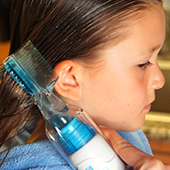 young girl with the lice preventer kit dispenser in her hair